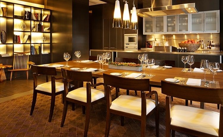 Restaurant met gedekte tafels en open keuken op de achtergrond